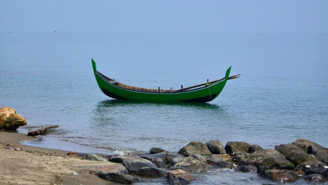 Perahu nelayan terombang ambing di pinggir pantai