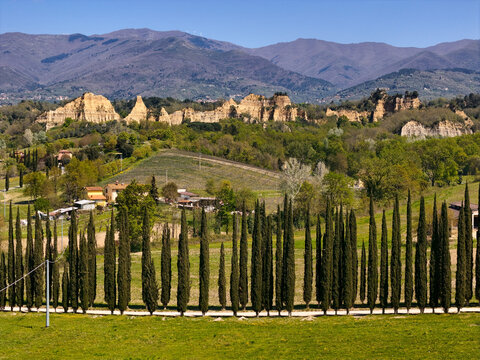 Aerial view of the Balze rock formations and a row of cypress trees in the Tuscan countryside with mountains in the background Reggello, Tuscany, Italy.