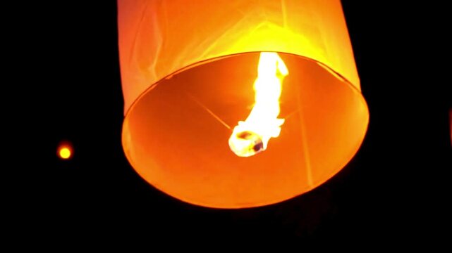 Young people release floating lanterns delicate in the night sky at Yi Peng Traditional celebration in Thailand, realistic photography, 4k 60Fps