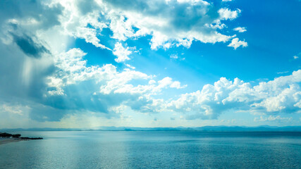 Obraz premium Tropical Nature clear sky and summer sea water under a clear blue sky with beautiful clouds and bright sunlight. Perfect for summer vacation and travel background 