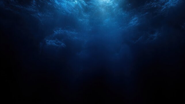deep blue ocean depths with sunbeams piercing the turbulent surface, a dark mysterious and tranquil underwater scene