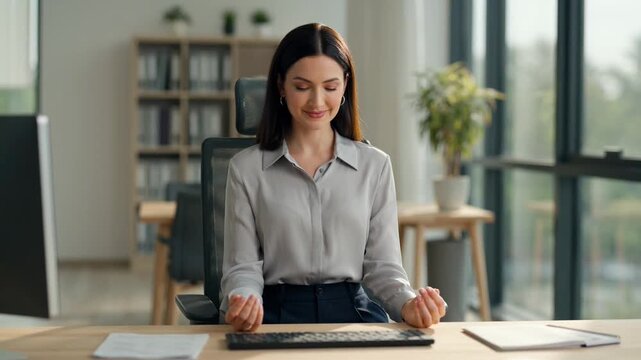 Woman takes mindful office meditation break at her desk