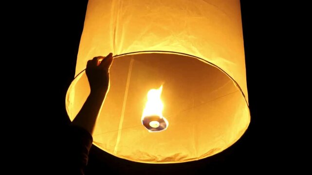 Young people release floating lanterns delicate in the night sky at Yi Peng Traditional celebration in Thailand, realistic photography, 4k 60Fps