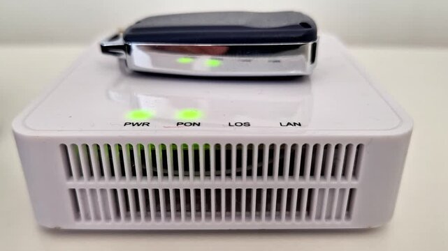 White network modem with four illuminated green indicator lights and ventilation slots, highlighting active connectivity, electronic function, and reliable household networking