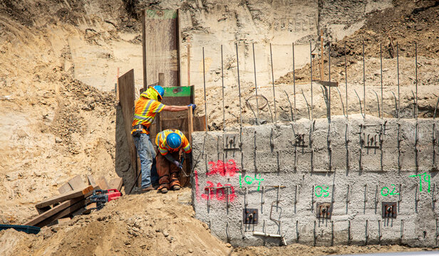 Construction workers on a project with retaining walls and rebar