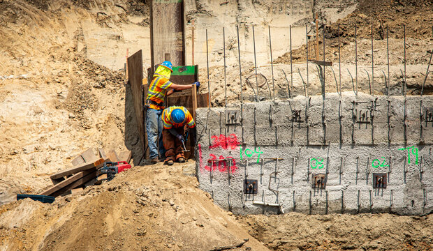 Construction workers on a project with retaining walls and rebar