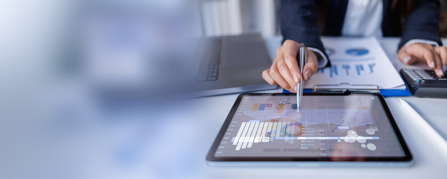 Hand and graph on tablet laptop screen at desk accounting, finance report and profit growth. Accountant, digital and budget for financial stats,