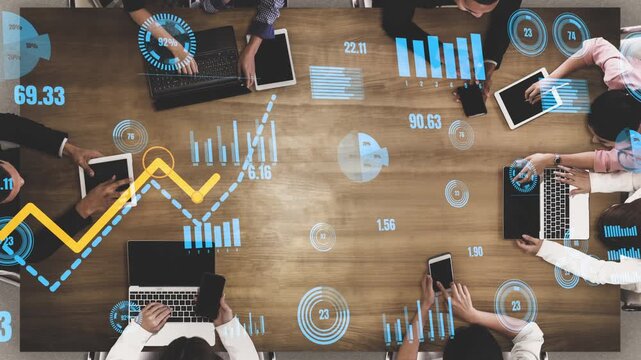 A dynamic business meeting portrayed from above, featuring professionals analyzing digital growth charts and financial data, fostering collaboration and strategic insights. Xenic