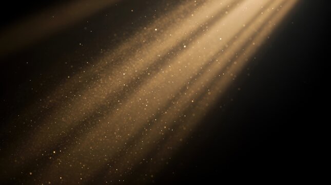 Golden dust particles illuminated by warm rays of light against a dark background, creating a magical and ethereal atmosphere.