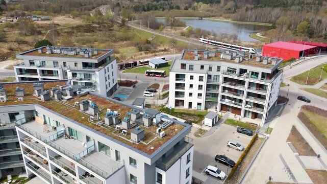 Modern apartment buildings with sustainable green roofs and integrated public transport hub; Suburban transit-oriented development; Eco-friendly urban infrastructure; Well-connected residential area