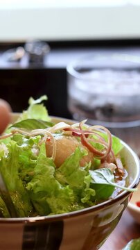 Close Up of Person Eating Fresh Vietnamese Noodle Salad with Chopsticks