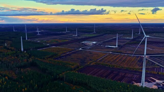 Wind farm under construction with turbines installed across a developing landscape. Aerial view shows expanding renewable energy infrastructure and ongoing site development.