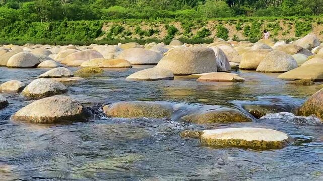 Tilt down beautiful green hill to underwater rocky stream at Sylhet, Bangladesh.