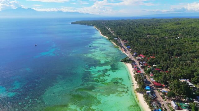 drone fly above San Juan coastline  town in Siquijor, Philippines. coral reef white sand beach and resort accommodation