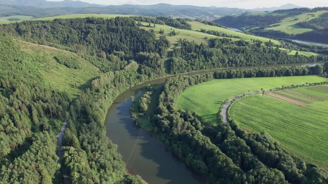 Aerial view of winding river through forest and green countryside