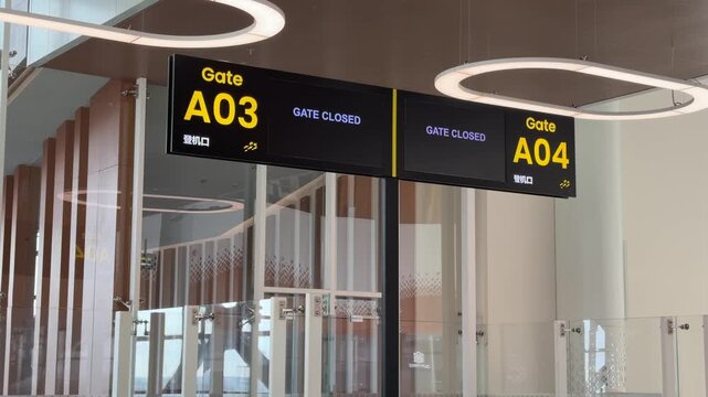 Departure gate sign display with boarding information screen inside modern airport terminal