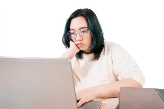 Thoughtful Young Woman Working on Laptop with Books on Desk Isolated on White