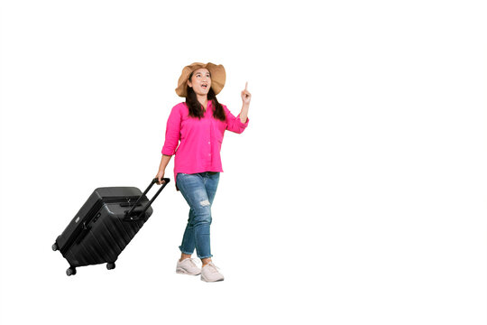 Excited Woman Traveler in Pink Shirt Carrying Suitcase and Pointing Upward on White Background