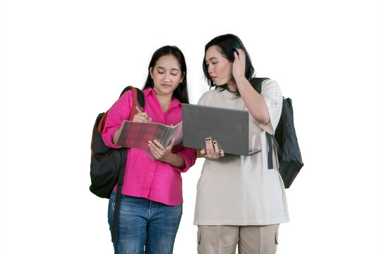Two Asian Female Students Studying Together with Laptop and Notebook on White Background