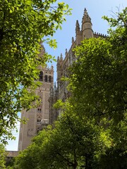 Naklejka premium Seville - Spain. 21 April 2026. The Giralda tower rises beside Seville Cathedral, uniting Moorish and Gothic grandeur in one of Spain’s most iconic silhouettes.