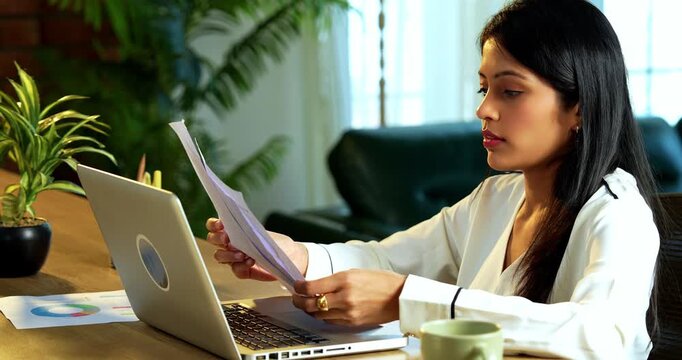 Indian young business lady getting irritated with spam call on her smartphone at workplace