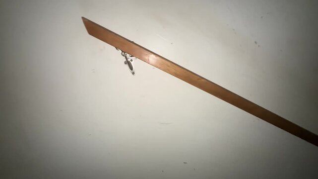 Wooden stair handrail mounted on wall with metal bracket showing interior home detail and safety feature