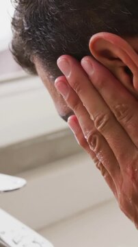 Vertical video: Cupping water from running faucet, man rinsing face at sink wearing smartwatch