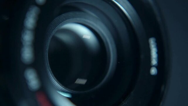macro shot of a professional video camera while it's lens is zooming. Camera Lens. Internal objective lens of a camera. light swipe through the lens.