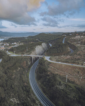 Aerial view of scenic autoestrada do val minor winding through majestic mountains and tranquil forest, Baiona, Pontevedra, Spain.