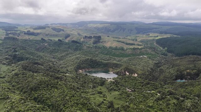 Drone push-in over geothermal valley and crater lakes in Waimangu New Zealand, volcanic landscapes and scenic nature view.