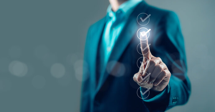 Businessman pressing digital checklist with glowing check marks, quality assurance, task completion, workflow management, compliance audit, productivity and modern business technology concept