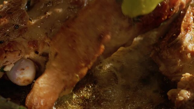 Lamb is placed in a hot pan and cooks as it sizzles. The meat releases juices and browns nicely. The cooking process shows how lamb can get a good texture and flavor.