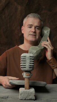 Prehistoric news presenter working in the TV studio, he is reading news and answering phone calls