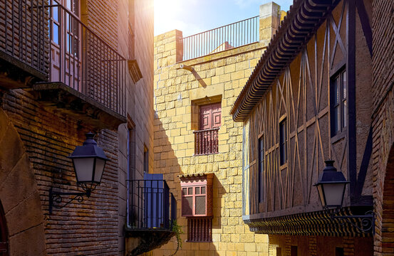 Medieval architecture with wooden balconies and old lanterns in Poble Espanyol, Barcelona, Catalonia, Spain.