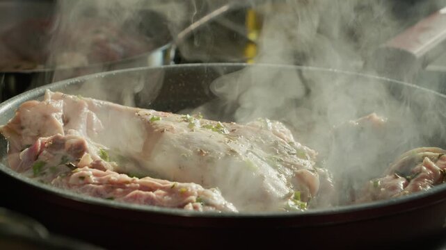 Fried lamb is cooked with a mix of spices in a kitchen. Steam rises as the meat absorbs the flavors. Cooking methods show how to blend spices properly.