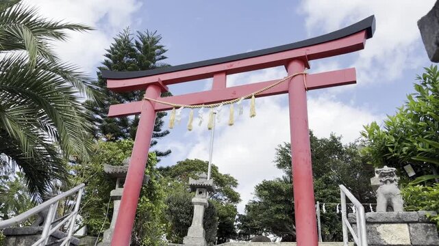 晴天の青空と神社の赤い鳥居、しめ縄と石段（日本沖縄県の風景）