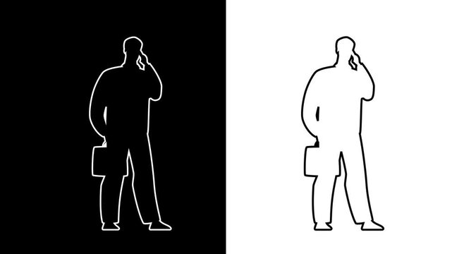 Silhouetted businessman talks on phone while carrying briefcase