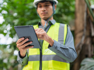 Asian engineer using tablet for digital monitoring and project management in engineering work. © Charlie's