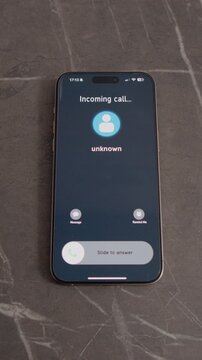 Vertical Screen: A smartphone displays an incoming call from an Unknown number. The phone is placed on a table. Viewers can see the screen and the call options available.