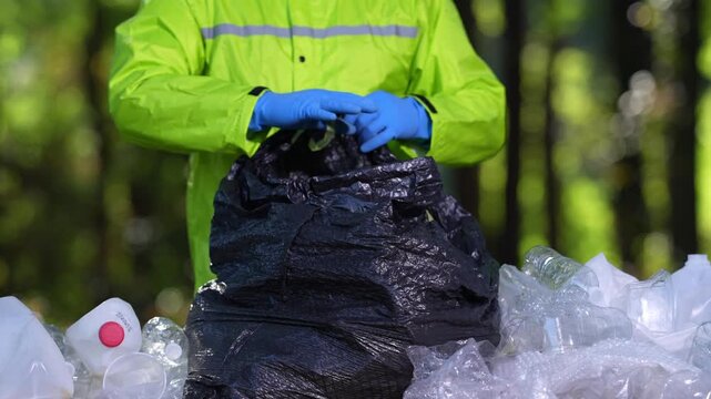 Ecology volunteer cleaning nature. Environmental hand holding waste. Plastic pollution threatens ecology. Recycle garbage to save forests. Volunteer against environmental pollution.
