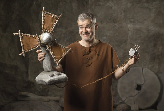 Happy Caveman Proudly Shows Off His Newly Invented Stone Electric Fan in a Cave