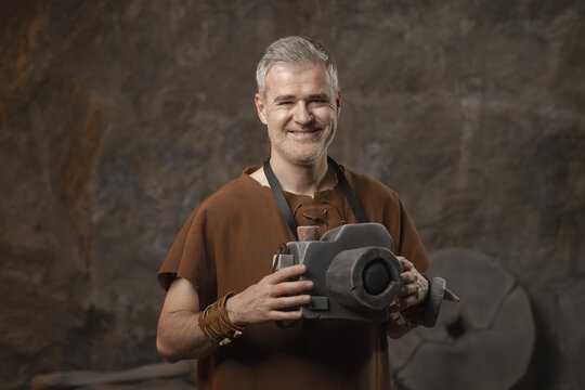 Funny Prehistoric Caveman Holding Primitive Stone Camera - Ancient Photography Concept
