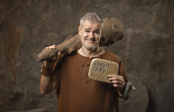 Funny Prehistoric Caveman Holding a Stone Credit Card - Ancient Shopping and Finance Concept