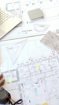 Vertical video: Tile sample entering right, design team testing over 1st Floor plan for finish