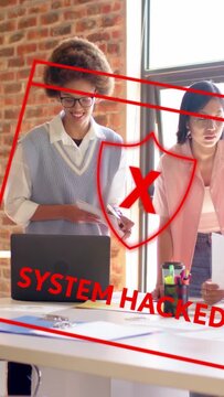Vertical video: Red 'SYSTEM HACKED' sweeping over laptop and papers, team investigating tech breach