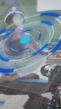 Vertical video: HUD growing over fitness coach on blue mat, guiding hand poses for DSLR instruction