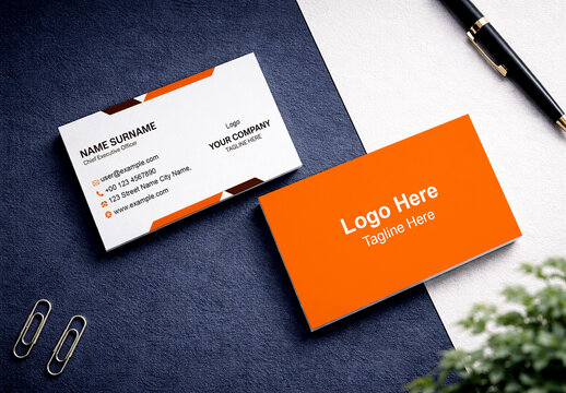 Two Business Card Mockups on Dark Blue and White Textured Surface with Pen and Paper Clips