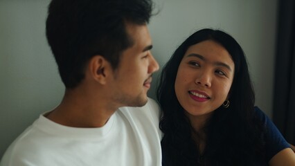 Obraz premium Smiling partners relaxing together in warm, intimate living space