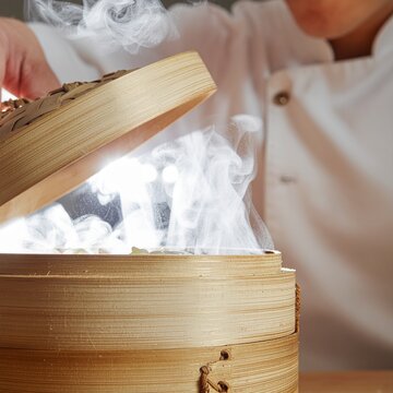 Chef ouvrant un panier vapeur en bambou d&eacute;gageant une fum&eacute;e chaude