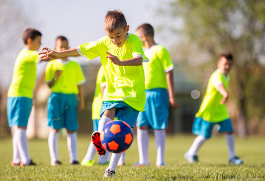 Young boy kicking soccer ball